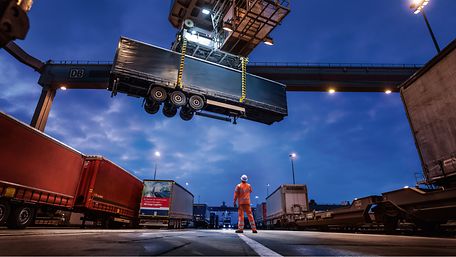 Semi-trailer being loaded onto a train by crane
