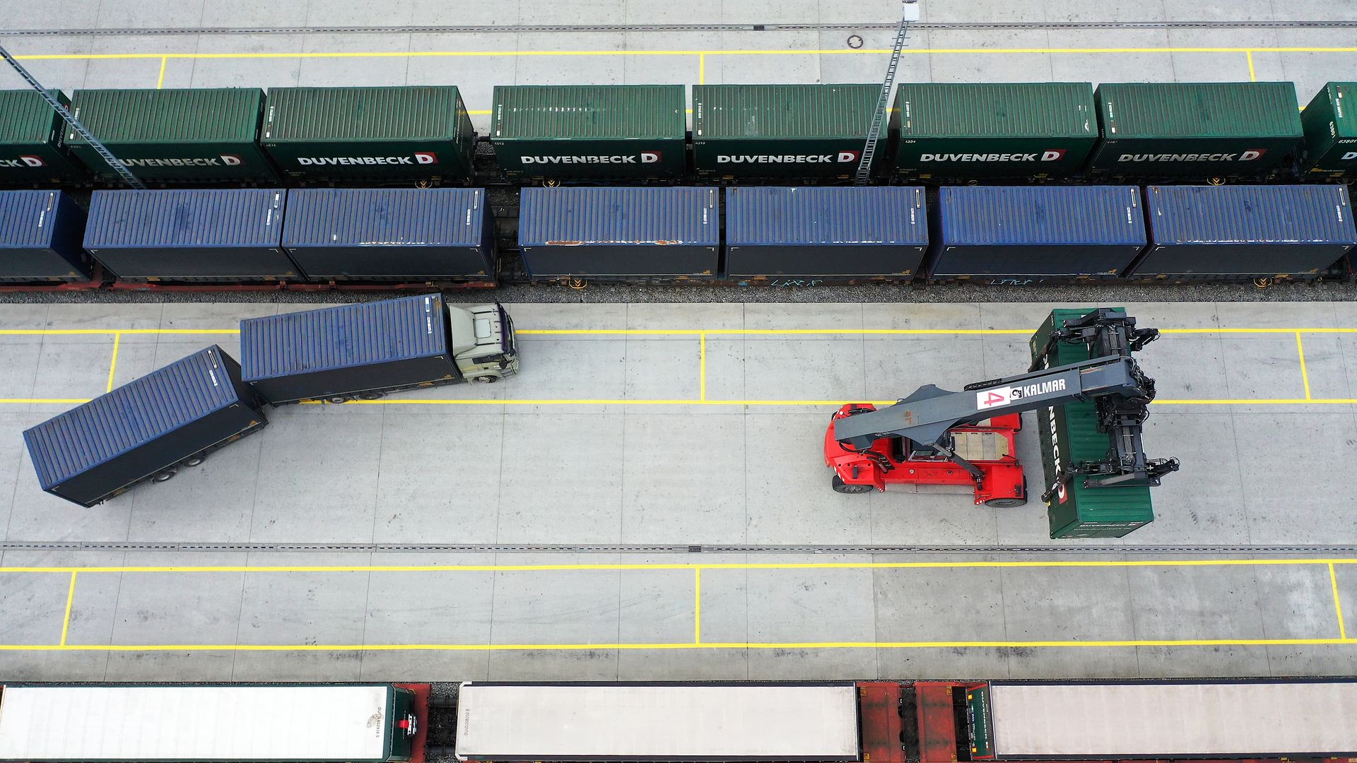 Reachstacker verlädt Container auf Güterzug