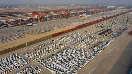Riesiger Container-Terminal mit geparkten Fahrzeugen