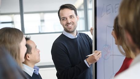  Mann im blauen Pullover an Flipchart