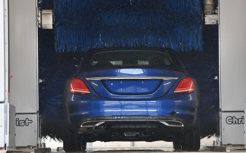 Blauer Pkw in Waschanlage von hinten