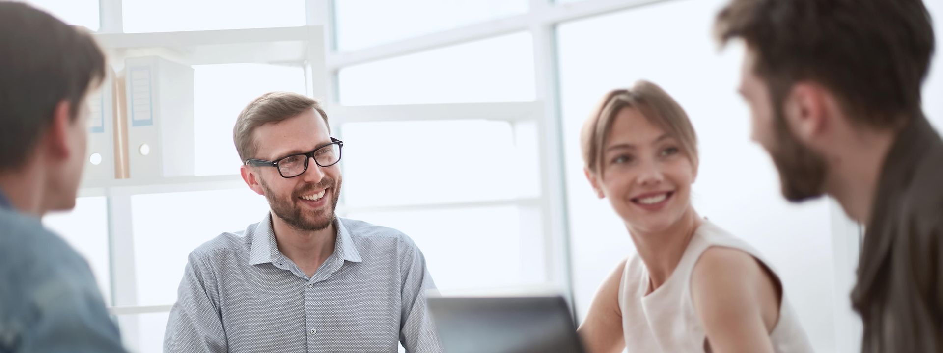 Smiling people at a desk in a bright office