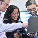 Three employees in front of a laptop