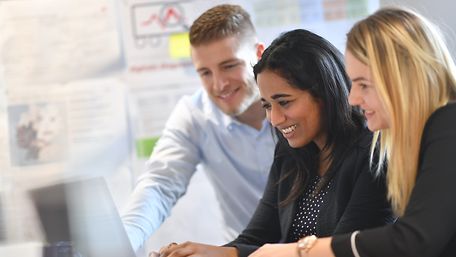 Three young people in front of a laptop