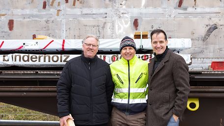 Das Team von DB Cargo Logistics und Mitarbeiter von Binderholz und Bürgermeister Schwarz vor einem beladenen Waggon.