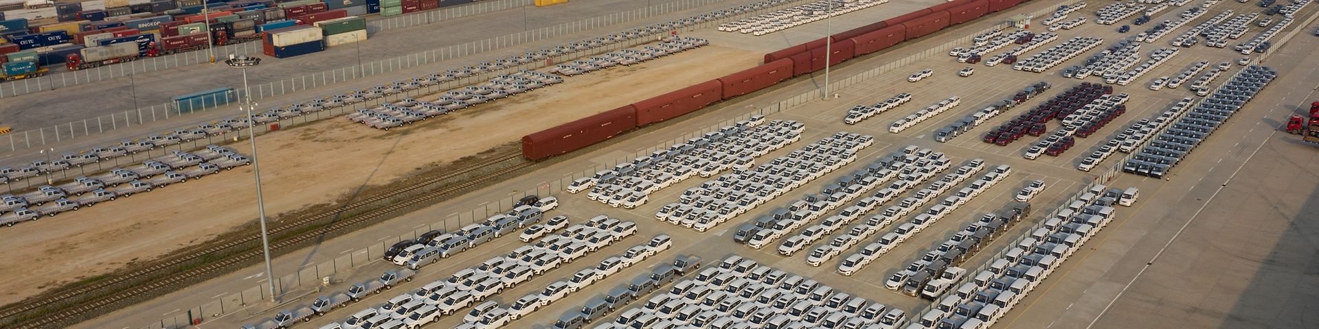 Riesiger Container-Terminal mit geparkten Fahrzeugen