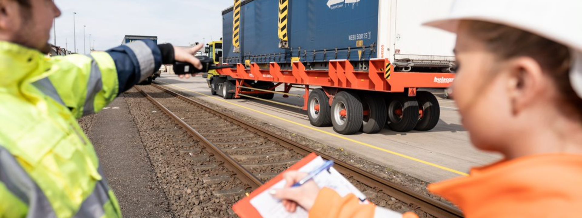 Two employees discuss lorry-to-train transhipment